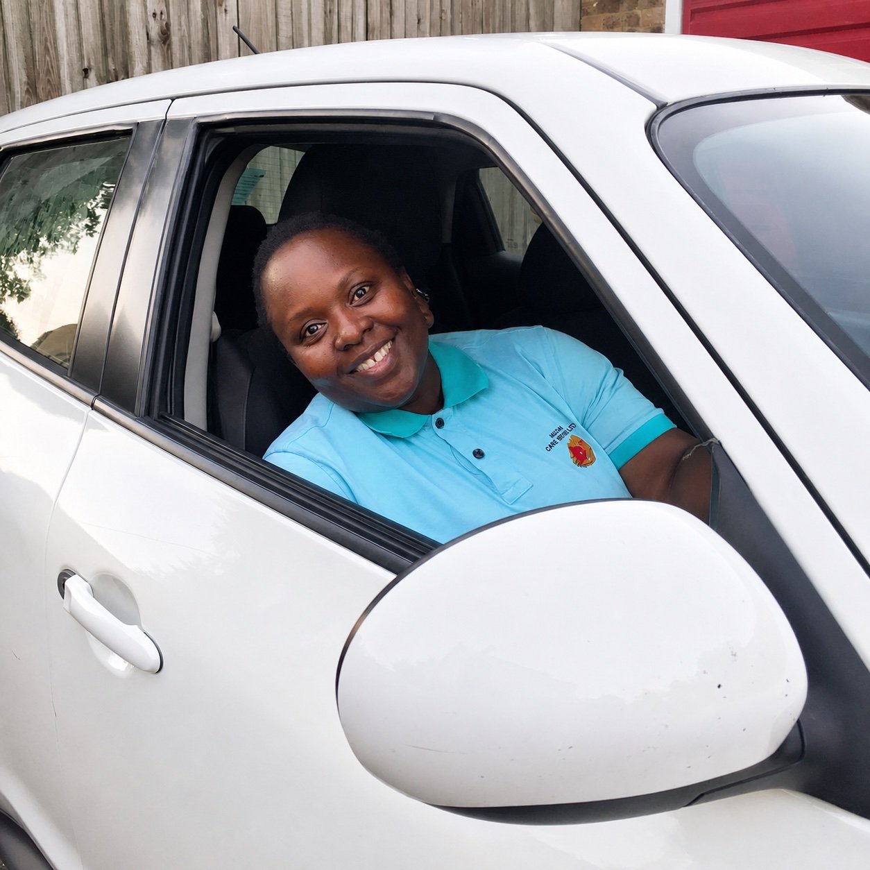 Paulina Lubega, Registered Manager of Muzaana Care Services, smiling in a Muzaana care uniform