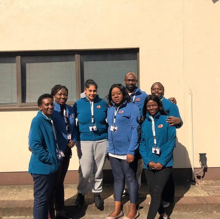 The Muzaana team, around eight carers in blue uniforms and lanyards, gathered outside together.